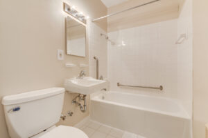Interior Unit Bathroom, well lit vanity mirror, shower/bathtub, white appliances, tile floor.