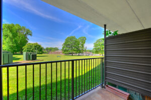 Exterior Unit Patio, Privacy divider, view of large grassy field, trees in the distance.